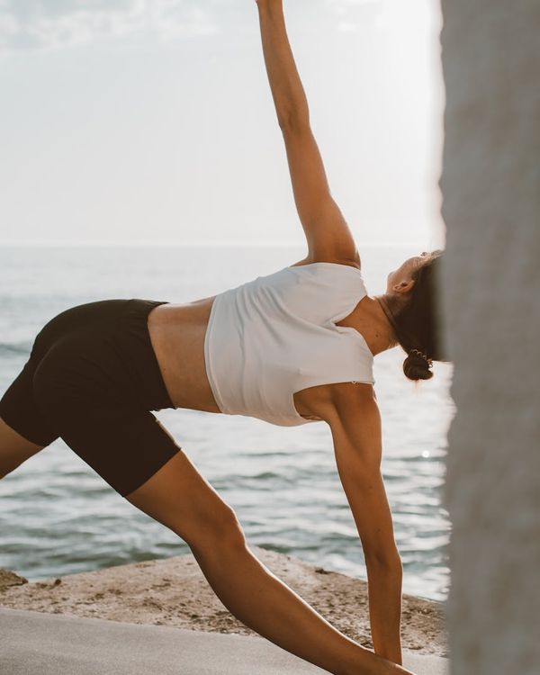 Person stretching outdoors during sunrise, feeling energized and refreshed.